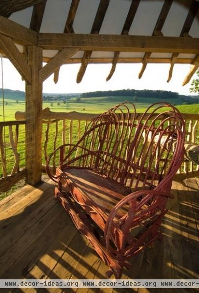 tropical porch by Hugh Lofting Timber Framing, Inc.